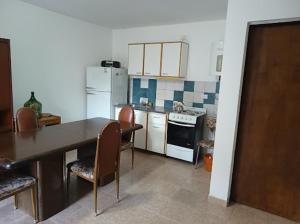 a kitchen with a table and chairs and a refrigerator at Departamentos Don Claudio in San Luis