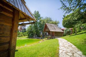 a log cabin with a path next to a house at Etno selo Stanišići Etno kuće in Dijelovi