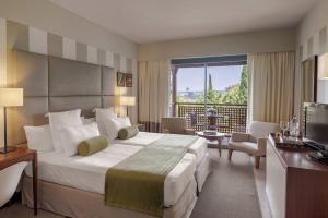 a hotel room with a large bed and a balcony at Precise Resort El Rompido-The Hotel in El Rompido