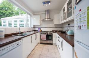 a kitchen with white appliances and a large window at Serene 4BR House with Garden & Conservatory in Nottingham