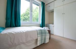 a bedroom with a bed and a large window at Serene 4BR House with Garden & Conservatory in Nottingham