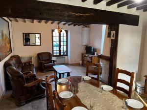 een woonkamer met een tafel en stoelen en een bank bij Les Arnusses 10 pers in Saints