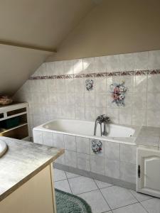 een badkamer met een bad en een wastafel bij Les Arnusses 10 pers in Saints
