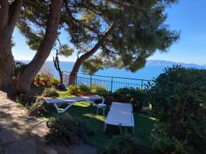 einen Tisch und Stühle im Gras mit Meerblick in der Unterkunft Sunny house in Porto Santo Stefano