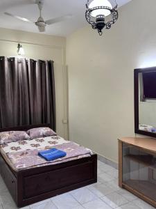a bedroom with a bed and a tv and a table at Villa Almeida in Panaji