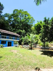 una casa azul con una valla delante de un patio en Sítio do Sossego, en Cachoeiras de Macacu