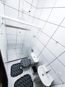 biała łazienka z toaletą i umywalką w obiekcie Sítio do Sossego w mieście Cachoeiras de Macacu