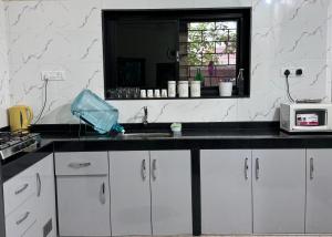 a kitchen with a sink and a microwave at Villa Almeida in Panaji