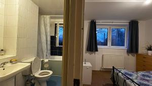 a bathroom with a sink and a toilet and a bed at Double room in Tooting Bec in London