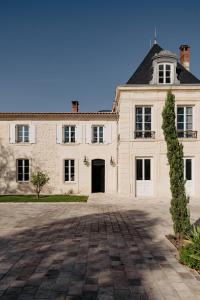 Château Grand-Arnaud في Vignac: منزل أبيض كبير مع ممر كبير