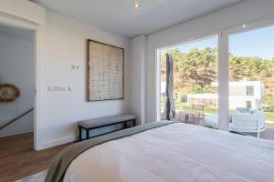 ein Schlafzimmer mit einem Bett und einem großen Fenster in der Unterkunft Villa Princesa in Almada