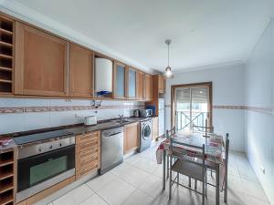 a kitchen with wooden cabinets and a table in it at Apartment Old Town Center Albufeira Walk to Beach in Albufeira