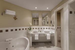 a bathroom with two sinks and a tub and a shower at Precise Resort El Rompido-The Hotel in El Rompido