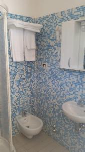a blue tiled bathroom with a sink and a toilet at MILANO in Marina di Pietrasanta