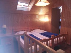 ル・ティヨにあるLocation chaletsの木製の部屋にベッド1台が備わるベッドルーム1室があります。