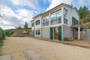 Villa la Collina Charme e Natura - Goelba في Marmi: بيت أبيض بأبواب خضراء وفناء