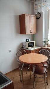 a kitchen with a table and chairs and a microwave at Mieszkanko nad jeziorem in Rosnowo