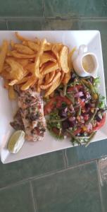a plate of food with fries and a sandwich and salad at Lodge des marseillais in Ouoran
