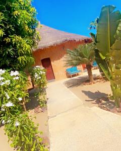 a house with a thatched roof and a pathway at Lodge des marseillais in Ouoran