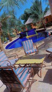 two chairs and a table next to a swimming pool at Lodge des marseillais in Ouoran