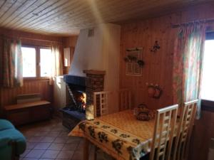 a dining room with a table and a fireplace at Location chalets in Le Thillot