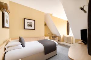 a hotel room with a bed and a tv at Royal Station Hotel- Part of the Cairn Collection in Newcastle upon Tyne