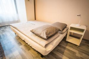 a bed in a room with a side table at Entire Flat in Kecskemét Center in Kecskemét