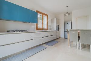 Villa la Collina Charme e Natura - Goelba في Marmi: مطبخ مع دواليب زرقاء وطاولة مع كراسي +10 صور