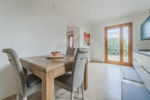 una cucina e una sala da pranzo con tavolo e sedie in legno di Villa la Collina Charme e Natura - Goelba a Marmi