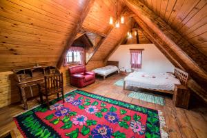 an attic bedroom with a bed and a desk in a room at Etno selo Stanišići Etno kuće in Dijelovi
