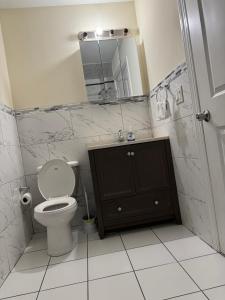 y baño con aseo, lavabo y espejo. en Affordable Luxury Home Near NYC & EWR, en Newark