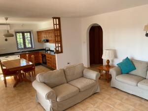 sala de estar con 2 sofás y cocina en Las Brisas, Villa 98, en Playa Blanca