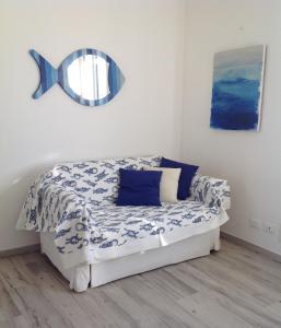 1 dormitorio con 1 cama con espejo en la pared en I colori del mare, en Villaggio del Pescatore