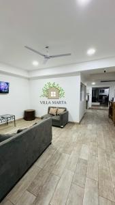 Hostal Villa Marta في سانتا آنا: غرفة معيشة مع أريكة وطاولة