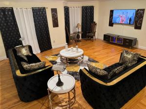 Sala de estar con 2 sofás y 2 mesas en Affordable Luxury Home Near NYC & EWR, en Newark