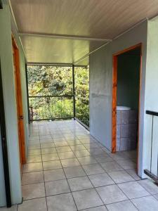 Habitación vacía con puerta abierta a un balcón en Cabaña Magui., en Aguas Zarcas