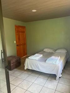 a bedroom with a bed and a wooden door at Cabaña Magui. in Aguas Zarcas