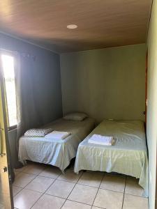 a bedroom with two beds in a room at Cabaña Magui. in Aguas Zarcas