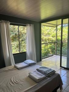 una camera con un letto con due cuscini sopra di Cabaña Magui. a Aguas Zarcas