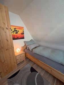 Un dormitorio con una cama y una mesa con una lámpara. en Ferienhaus Eisfelder Blick, en Eisfeld