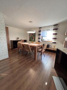 Un comedor con mesa y sillas y un televisor. en Ferienhaus Eisfelder Blick, en Eisfeld 2 fotos más