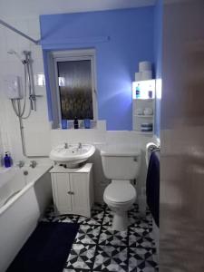 a bathroom with a white toilet and a sink at Twin room in Prescot Homestay in Prescot