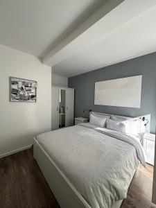 sypialnia z dużym białym łóżkiem i szarą ścianą w obiekcie Apartment Margita w Rovinj