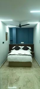 a bedroom with a bed with blue walls and a ceiling at Nebo Suites in Visakhapatnam