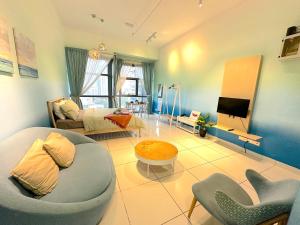 a living room with a couch and a tv at 3 Towers Jalan Ampang By Serenity Vacation Homes in Kuala Lumpur