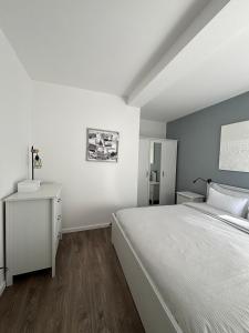 a white bedroom with a bed and a refrigerator at Apartment Margita in Rovinj