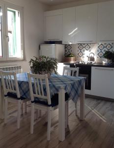 cocina con mesa y sillas y cocina con fogones en I colori del mare, en Villaggio del Pescatore