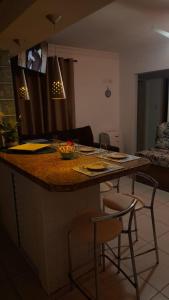 cocina con encimera con 2 sillas y mesa en Apartamento em Ubatuba- centro - apartamento 2 quartos com ar cond, en Ubatuba