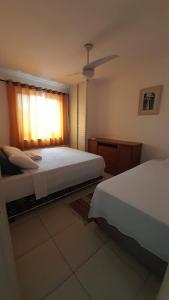 Giường trong phòng chung tại Apartamento em Ubatuba- centro - apartamento 2 quartos com ar cond