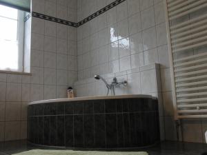 eine Badewanne mit einem Wasserhahn im Bad in der Unterkunft Ferienhaus Belle - FEWO Rose in Daschow